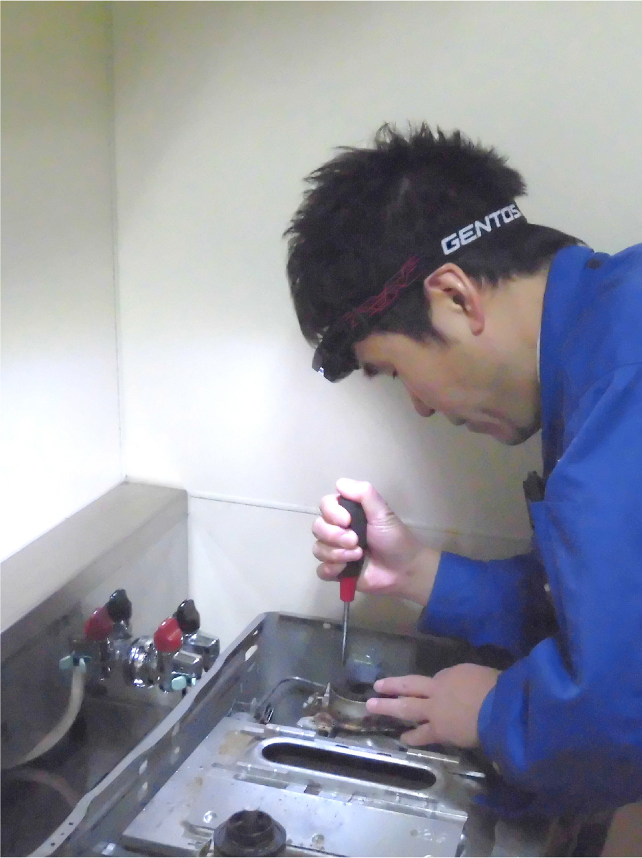 ガスキッチンを点検している男性作業員